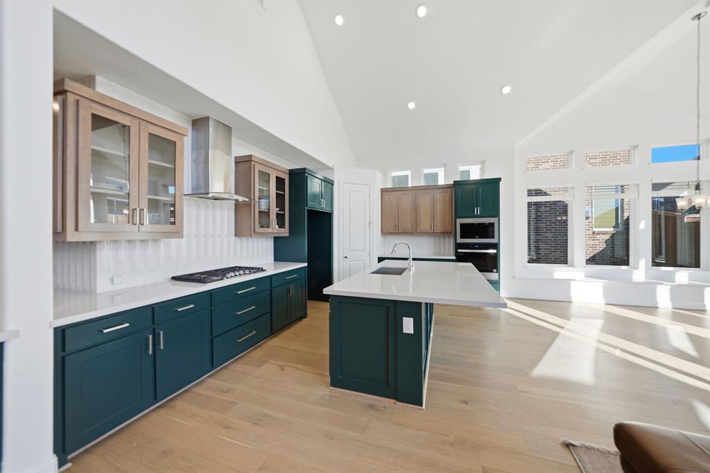 1227 Calebria Way Fate, TX 75087 - Photo 5 of 34 a kitchen with stainless steel appliances kitchen island granite countertop a stove and a sink