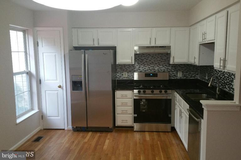6367 Racetec Place Springfield, VA 22150 - Photo 15 of 25 a kitchen with granite countertop a refrigerator and a stove