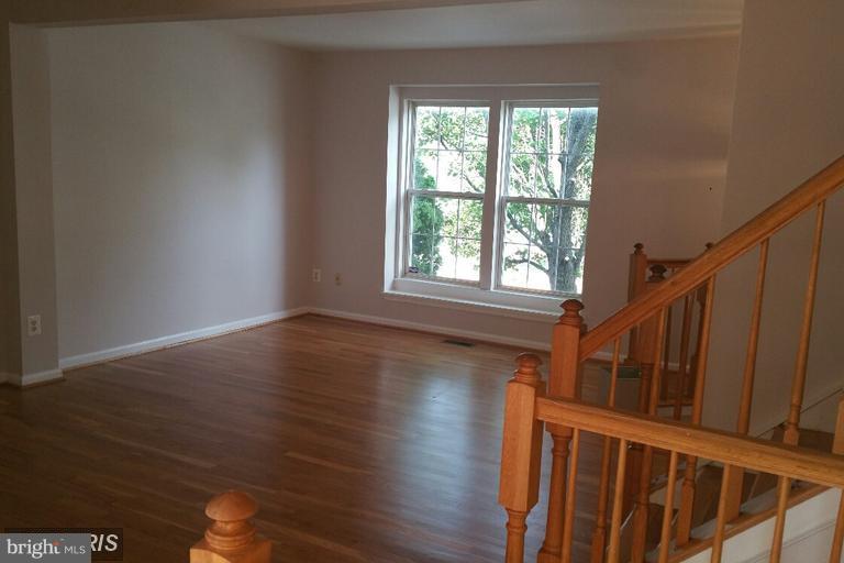 6367 Racetec Place Springfield, VA 22150 - Photo 17 of 25 a view of a hallway with wooden floor and staircase