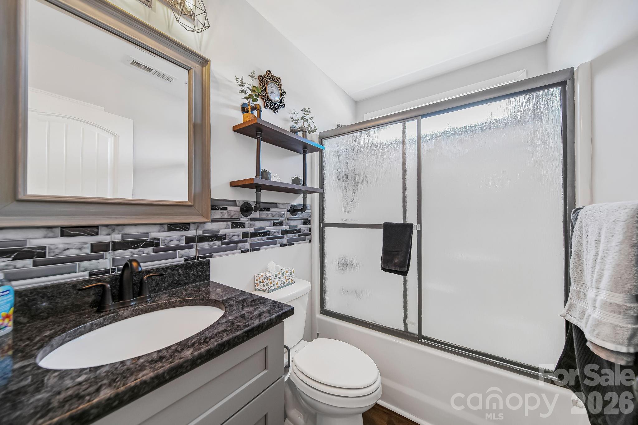 1189 West Elizabeth Street Pageland, SC 29728 - Photo 24 of 37 a bathroom with a granite countertop sink toilet mirror and shower