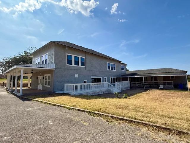 a front view of house with yard and trees in the background