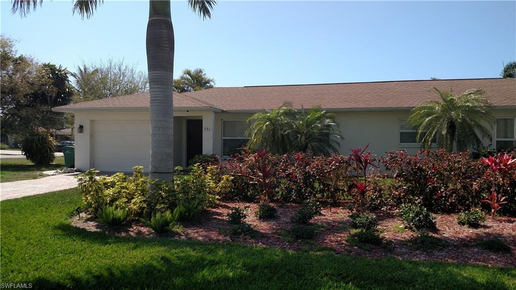 595 101st Avenue North Naples, FL 34108 - Photo 5 of 16 Single story home featuring a garage, stucco siding, a shingled roof, and driveway
