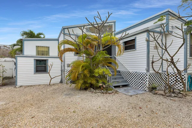 a view of a house with a yard and wooden fence