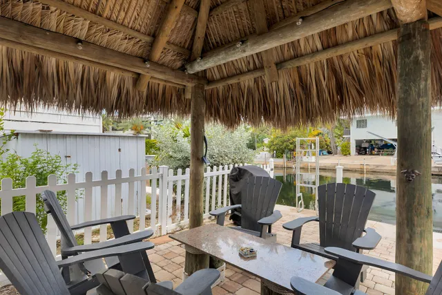 a view of a chairs and table in patio with wooden fence