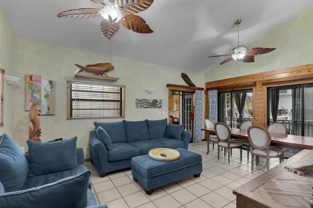 a living room with furniture a ceiling fan and a window