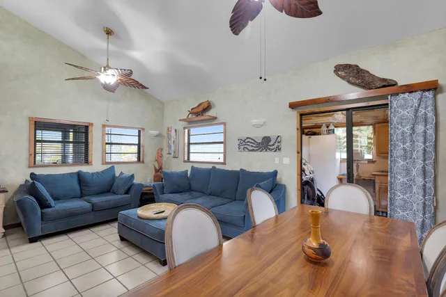 a living room with furniture a ceiling fan and a window