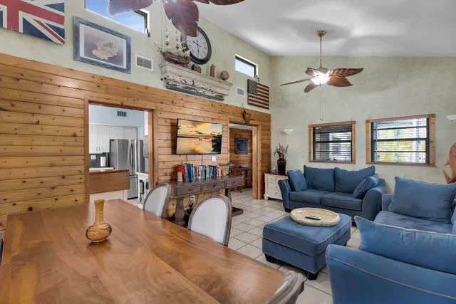 a living room with furniture a chandelier and a flat screen tv