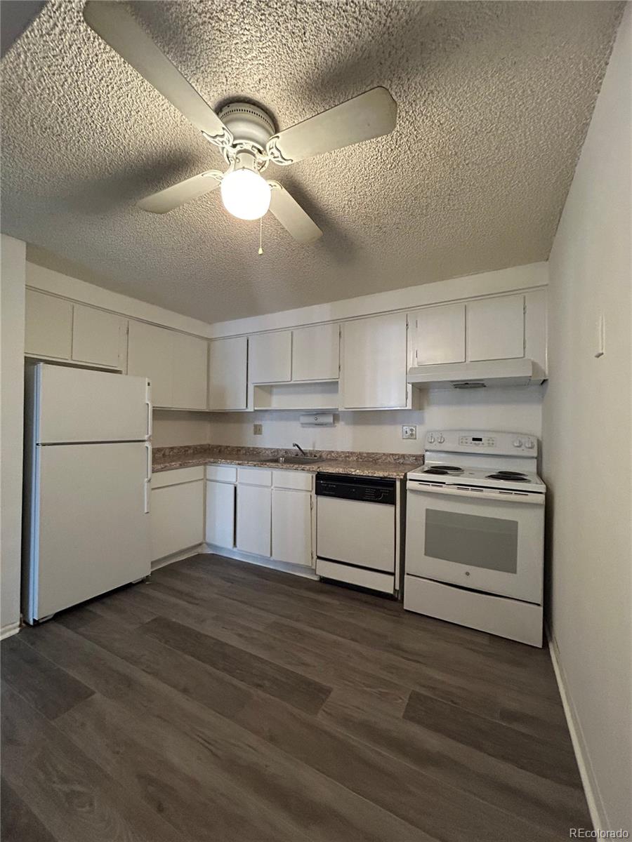 1306 South Parker Road, Unit 167 Denver, CO 80231 - Photo 3 of 14 a kitchen with granite countertop white cabinets and white appliances