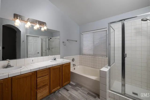 a bathroom with a sink double vanity mirror and a bathtub