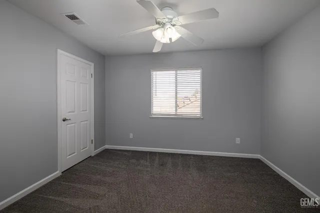 an empty room with a window and a fan