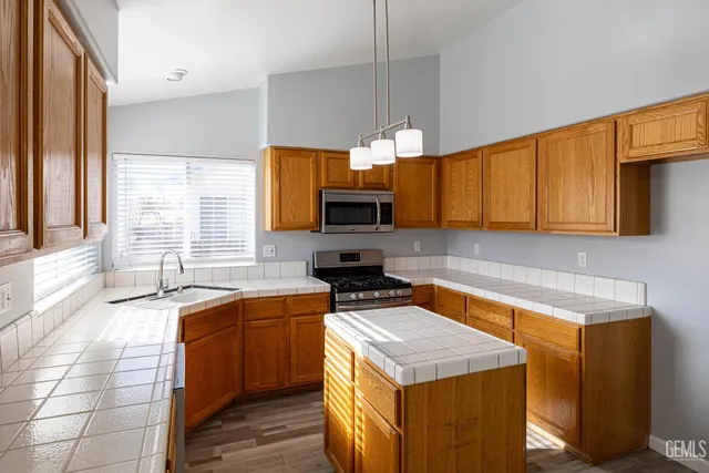 a kitchen with a sink a counter top space cabinets and stainless steel appliances