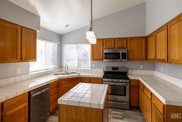 a kitchen with granite countertop a stove a sink and a microwave