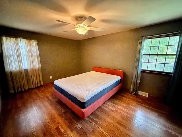 a bedroom with a bed and wooden floor