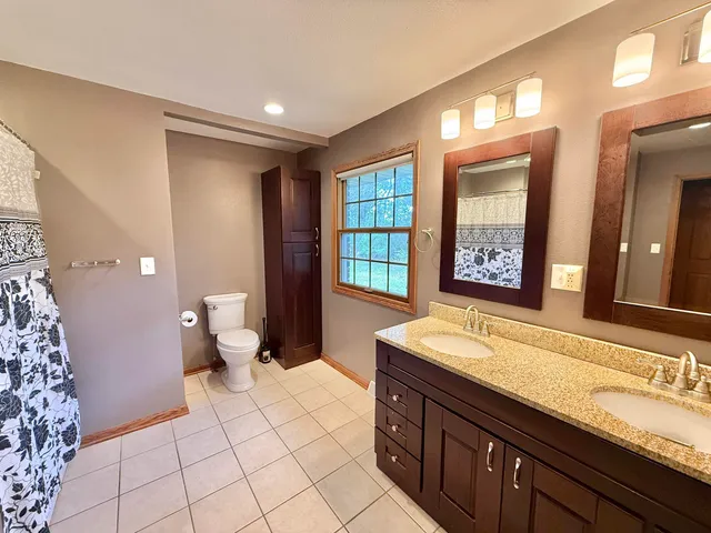 a spacious bathroom with a granite countertop sink mirror and toilet