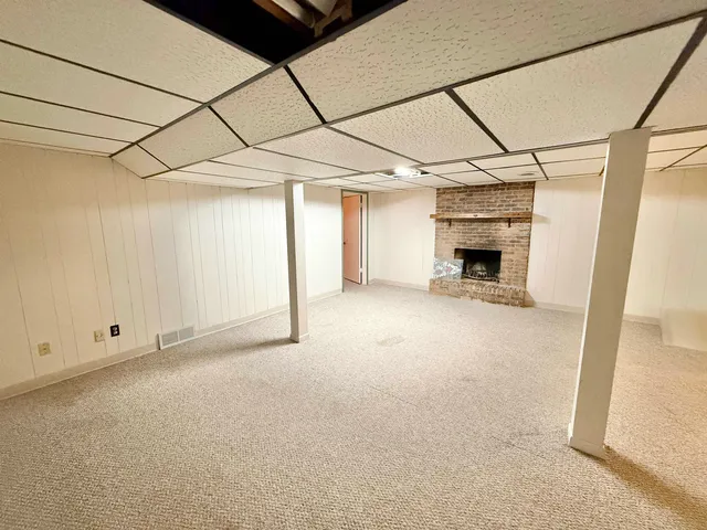 a view of a livingroom with a fireplace and a window