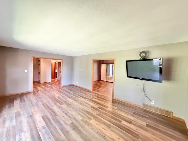 a view of a room with wooden floor and cabinet