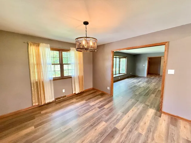 a view of a room with wooden floor staircase and a kitchen space