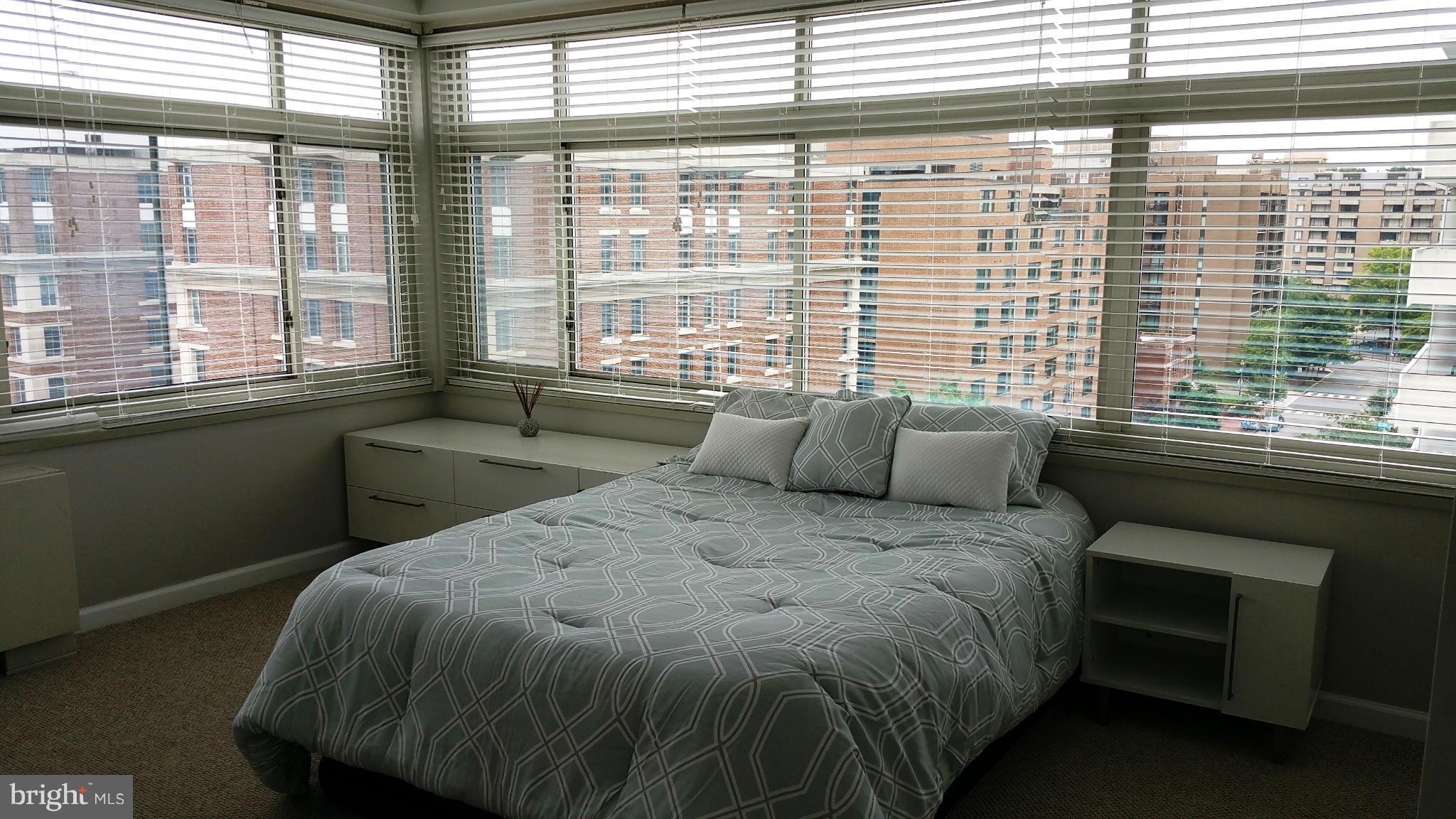 2401 H Street Northwest, Unit 904 Washington, DC 20037 - Photo 11 of 25 a bed sitting in a bedroom next to a window