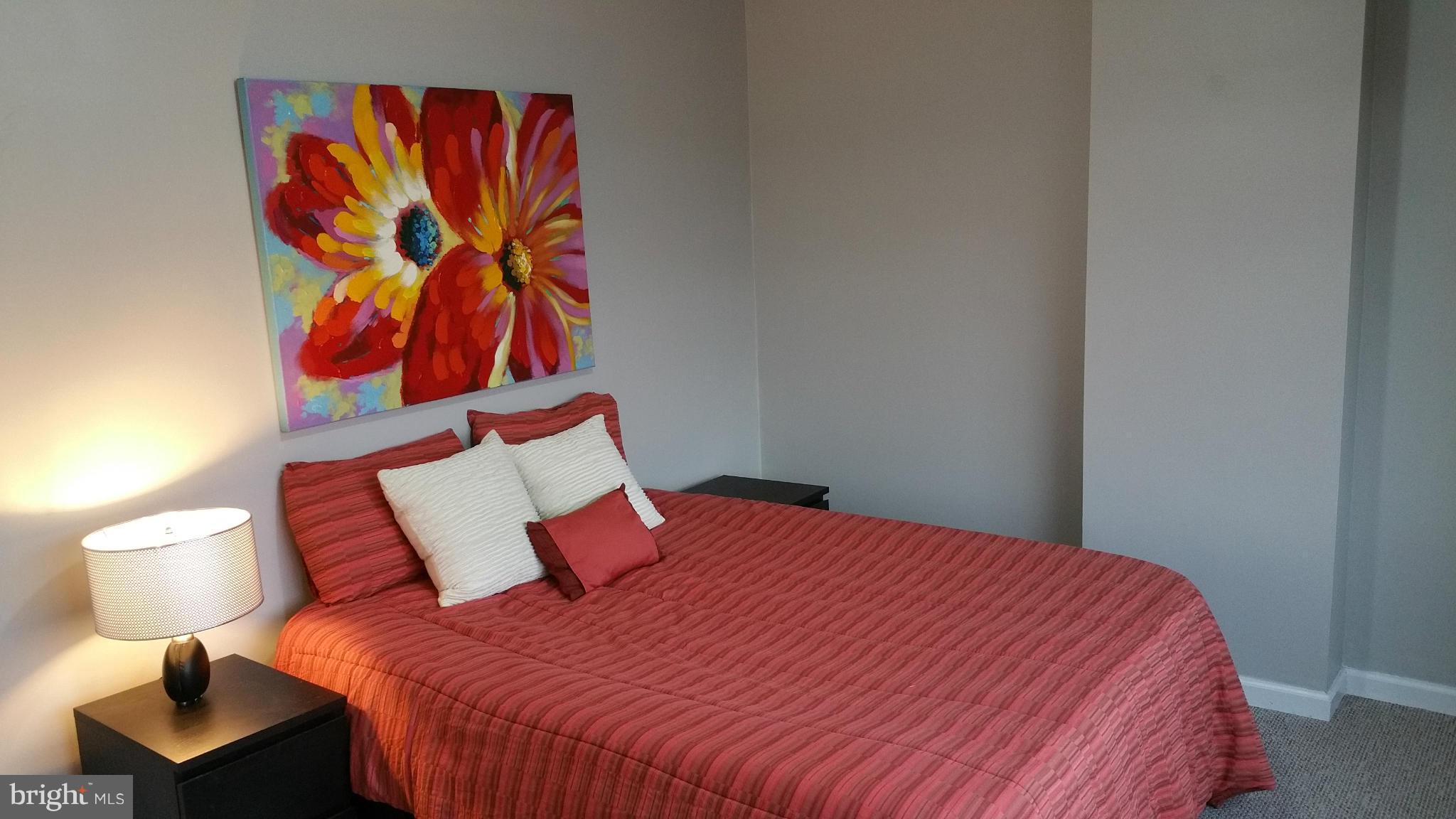 2401 H Street Northwest, Unit 904 Washington, DC 20037 - Photo 13 of 25 a bedroom with a bed and painting on the wall