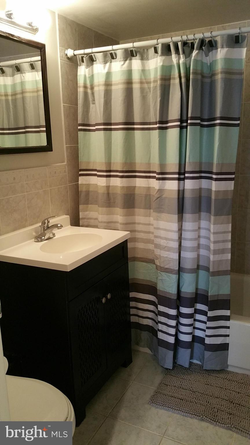 2401 H Street Northwest, Unit 904 Washington, DC 20037 - Photo 15 of 25 a bathroom with a sink a mirror and shower