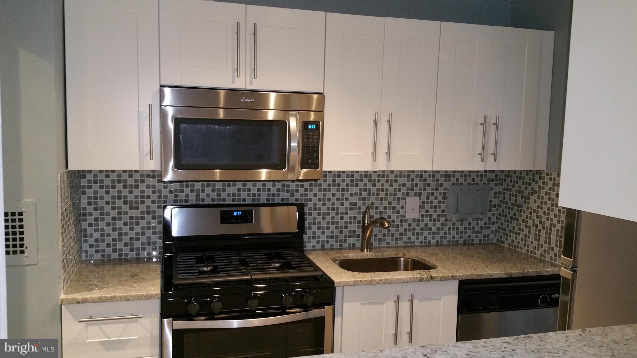 2401 H Street Northwest, Unit 904 Washington, DC 20037 - Photo 6 of 25 a kitchen with granite countertop a stove and a sink