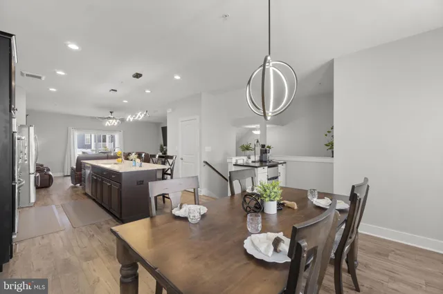 a very nice looking dining room with kitchen island furniture a mirror and wooden floor