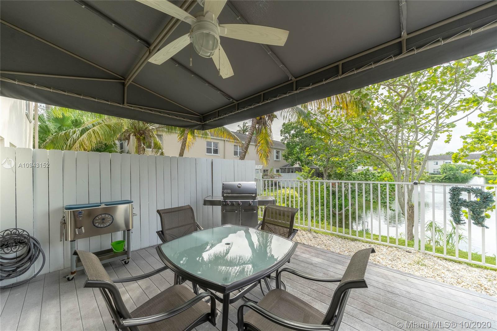 5580 Southwest 70th Place South Miami, FL 33155 - Photo 12 of 13 a patio with wooden floor a yard a table and chairs