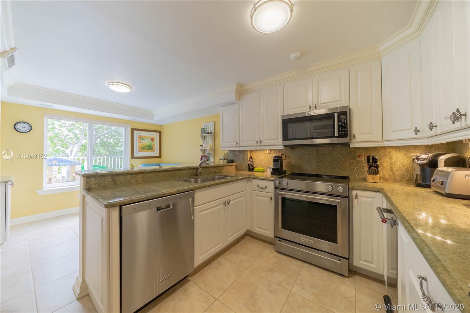 5580 Southwest 70th Place South Miami, FL 33155 - Photo 3 of 13 a kitchen with stainless steel appliances granite countertop a stove a sink and a microwave