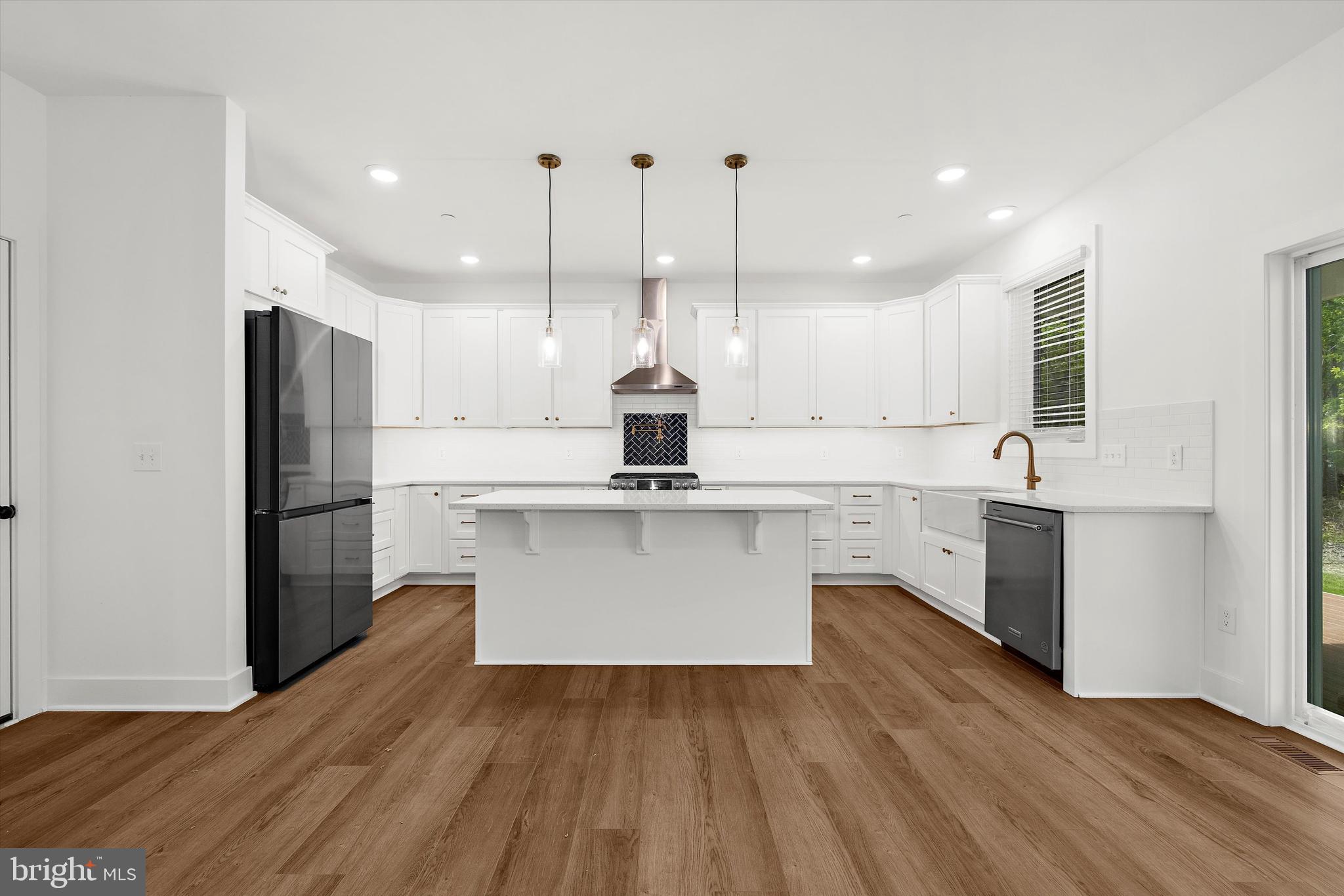 1807 Mountain Bay Road Pasadena, MD 21122 - Photo 22 of 75 a large kitchen with cabinets wooden floor and stainless steel appliances
