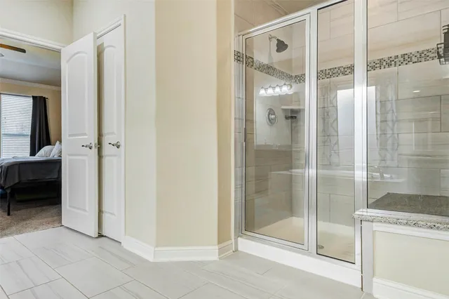 a bathroom with a shower and a glass door
