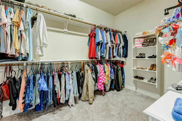 a view of walk in closet with clothes
