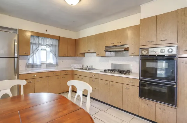 a kitchen with stainless steel appliances granite countertop a stove a sink and a refrigerator