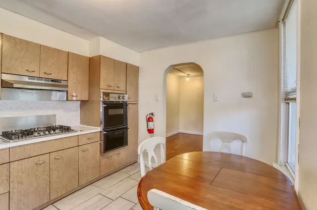 a kitchen with stainless steel appliances granite countertop a refrigerator a stove and white cabinets