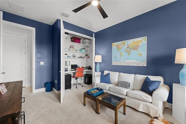 a living room with furniture and a painting on the wall