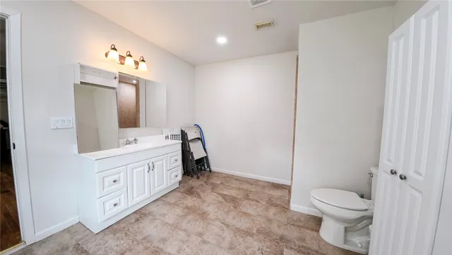 a bathroom with a double vanity sink toilet and mirror