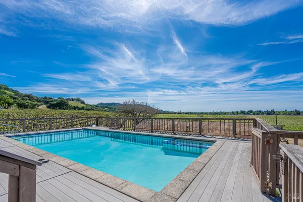 a view of a house with pool and chairs