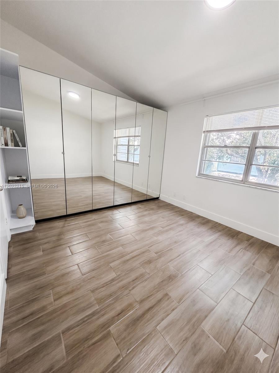 13 Southwest 3rd Street, Unit 13 Pompano Beach, FL 33060 - Photo 28 of 44 an empty room with wooden floor and windows