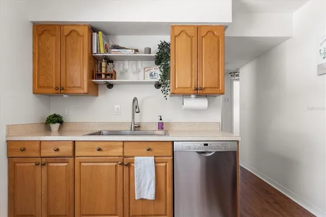 a kitchen with stainless steel appliances granite countertop a sink a stove and a wooden cabinets