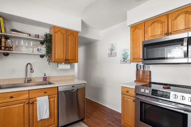 a kitchen with stainless steel appliances a stove a microwave and wooden cabinets