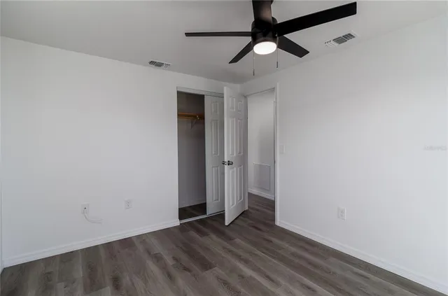 a view of empty room with wooden floor