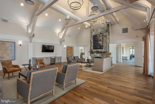 a living room with couches and kitchen view with wooden floor