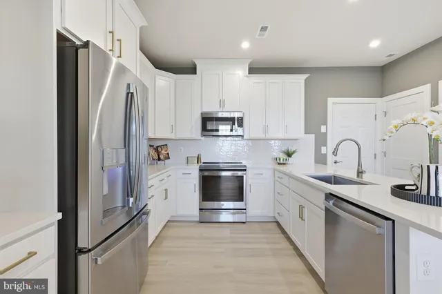a kitchen with stainless steel appliances granite countertop a refrigerator stove and sink