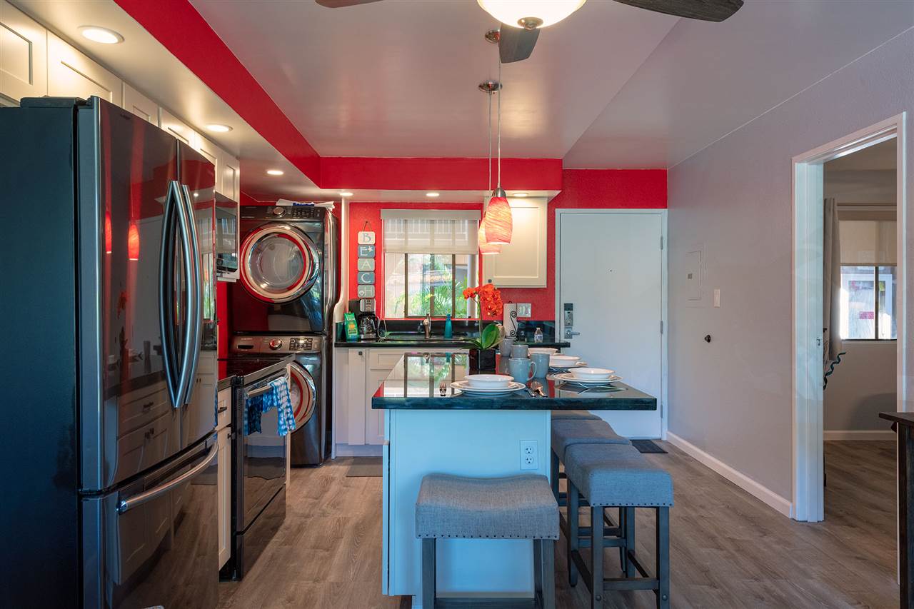 2219 South Kihei Road, Unit B104 Kihei, HI 96753 - Photo 11 of 27 a kitchen with stainless steel appliances kitchen island granite countertop a table and chairs in it