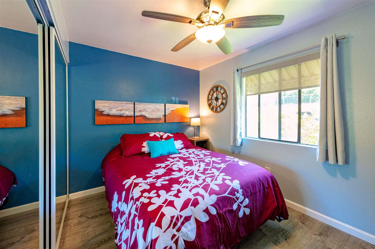 2219 South Kihei Road, Unit B104 Kihei, HI 96753 - Photo 17 of 27 a bedroom with a large bed and a chandelier