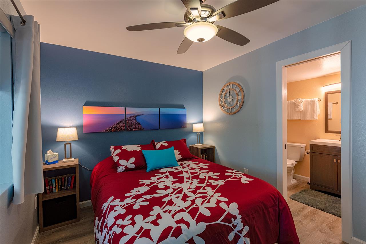 2219 South Kihei Road, Unit B104 Kihei, HI 96753 - Photo 8 of 27 a bedroom with a bed and a chandelier