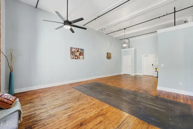 a view of a livingroom with wooden floor and a ceiling fan