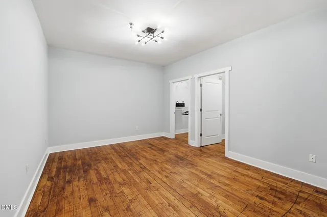 a view of empty room with wooden floor