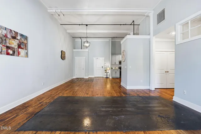 a view of empty room with wooden floor