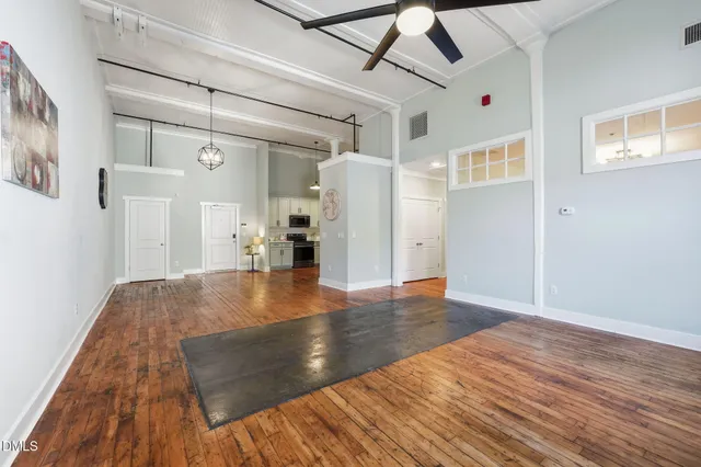 a kitchen with a refrigerator stove and wooden floor