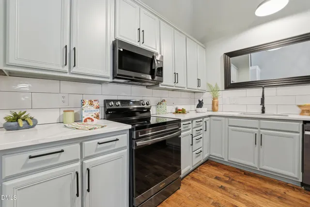 a kitchen with granite countertop white cabinets stainless steel appliances and sink
